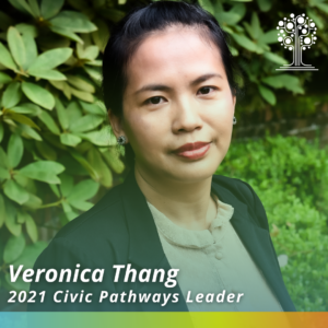 2021 Civic Pathways Leader, Veronica Thang, headshot of woman in blazer with green foliage behind her