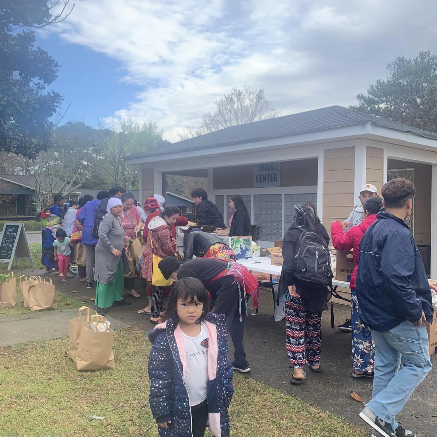 volunteer event with tables full of food, people standing around them