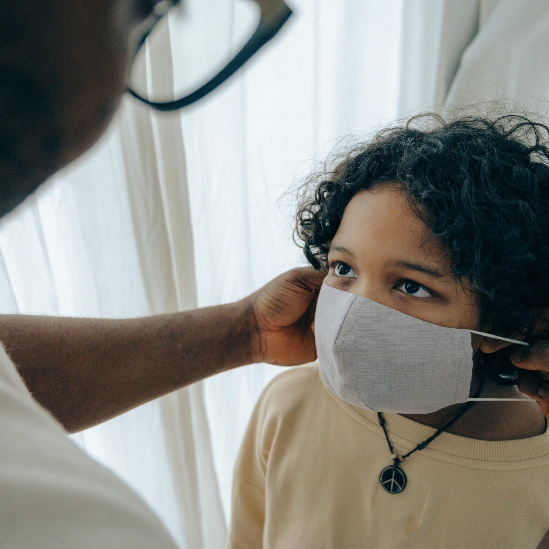 person putting a mask on a child supporting their health and wellness