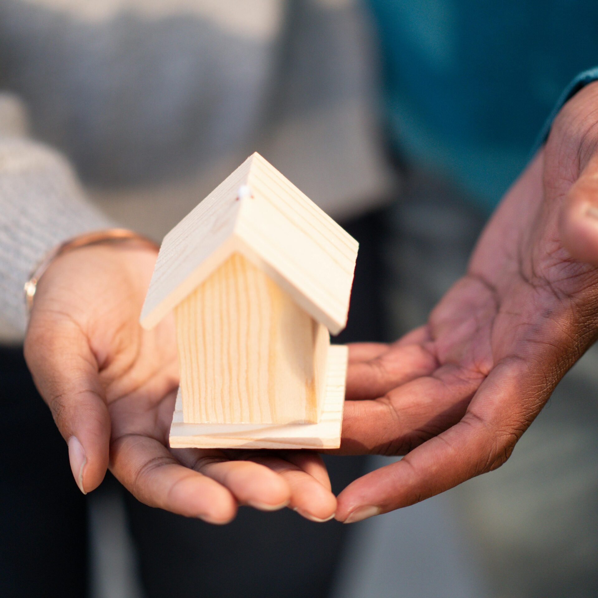 hands holding a house, housing support